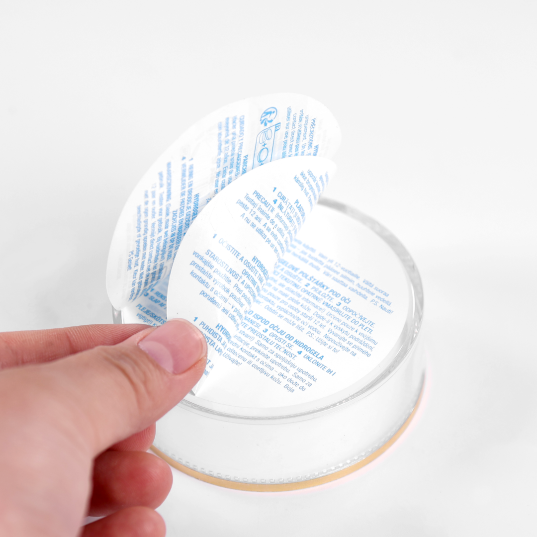 Booklet label being peeled open on a white jar
