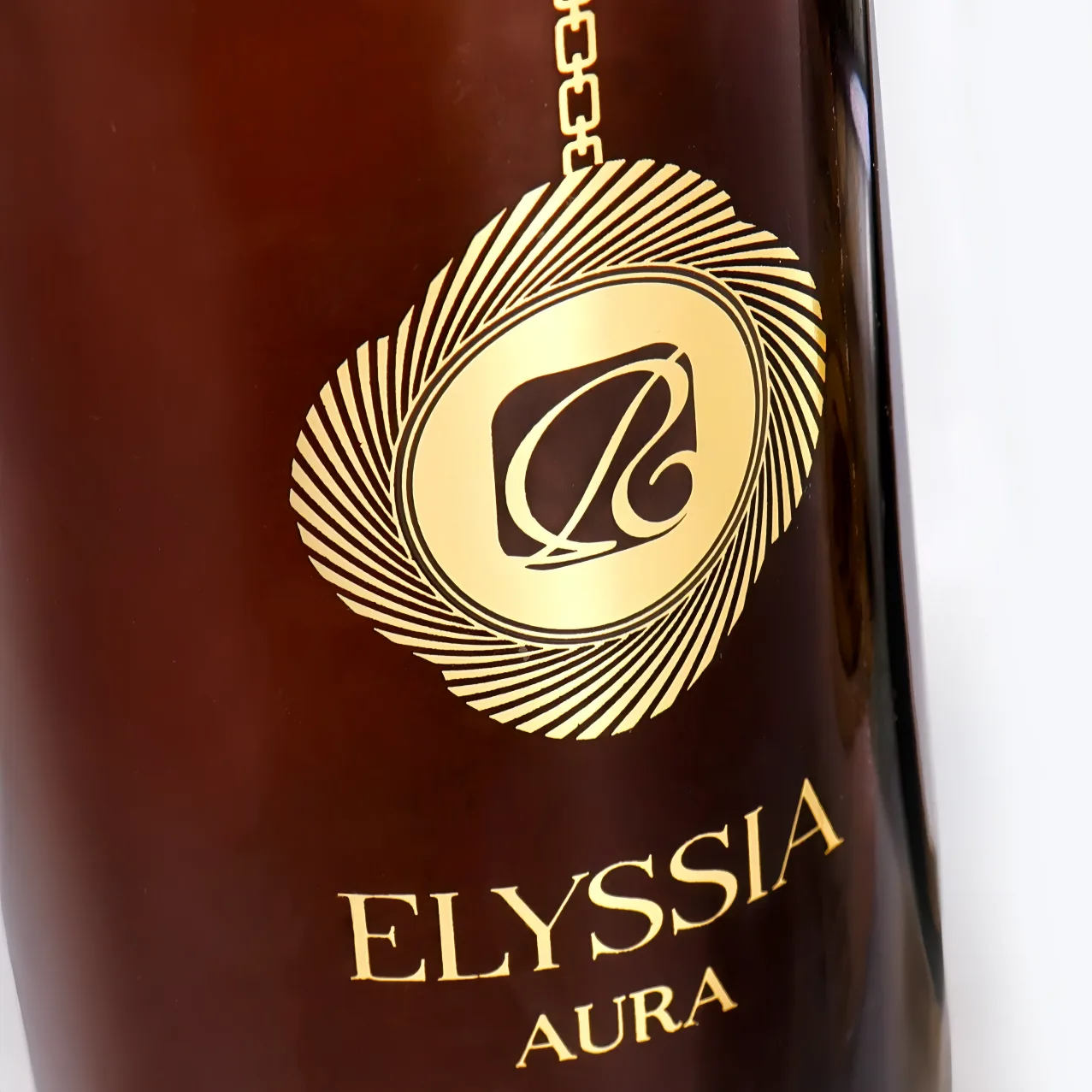 Hot foil stamping detail - radiating gold logo on dark perfume bottle