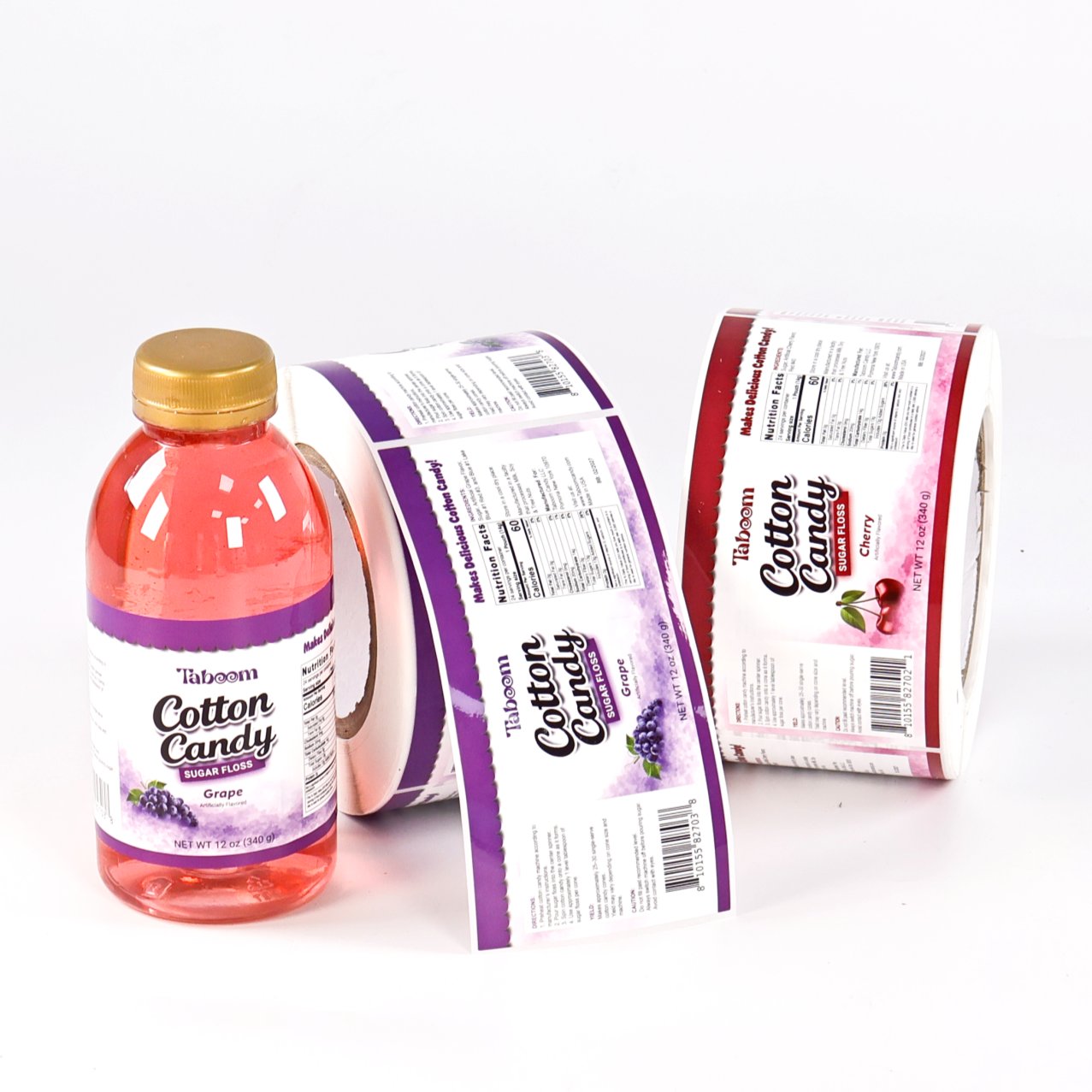 Beverage bottle with a printed food label next to two rolls of labels showing the front panel and the nutrition facts back panel