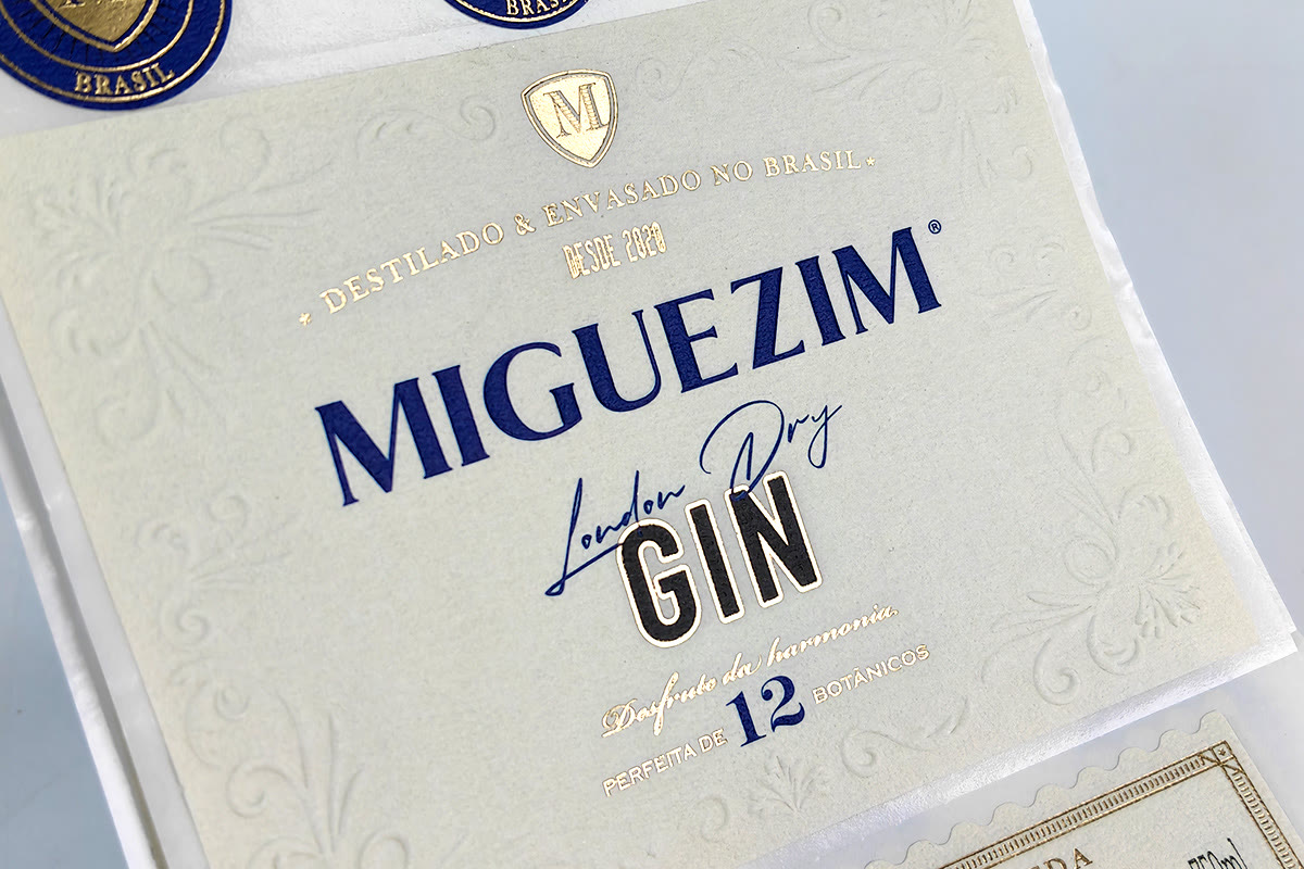 White textured specialty paper gin label with embossed pattern and blue and gold foil